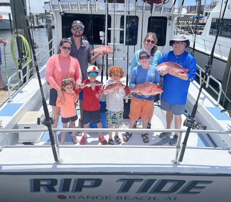 A family group with their red snapper catch on the stern of the Rip Tide
