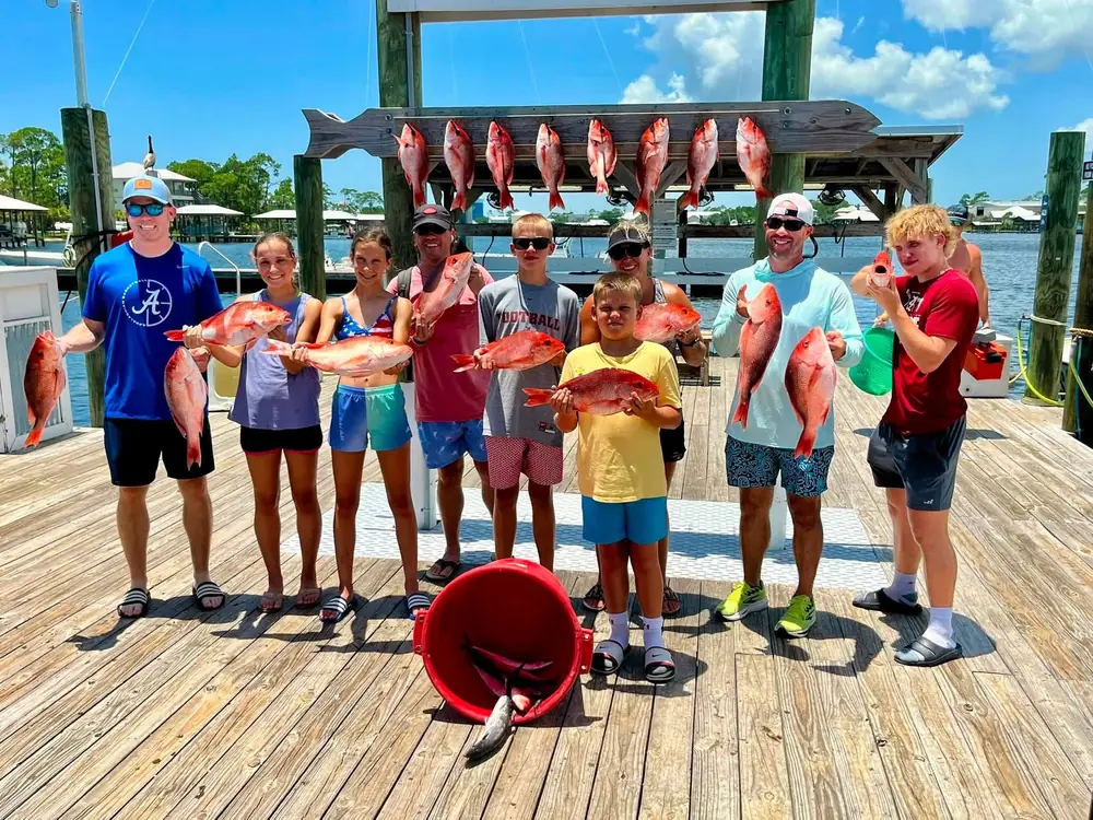A charter party with red snapper under a blue Gulf sky
