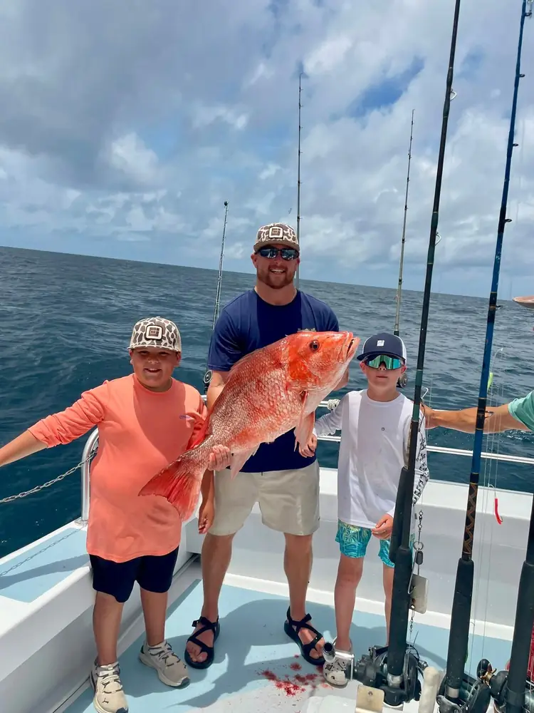 Two anglers with red snapper on the back deck offshore