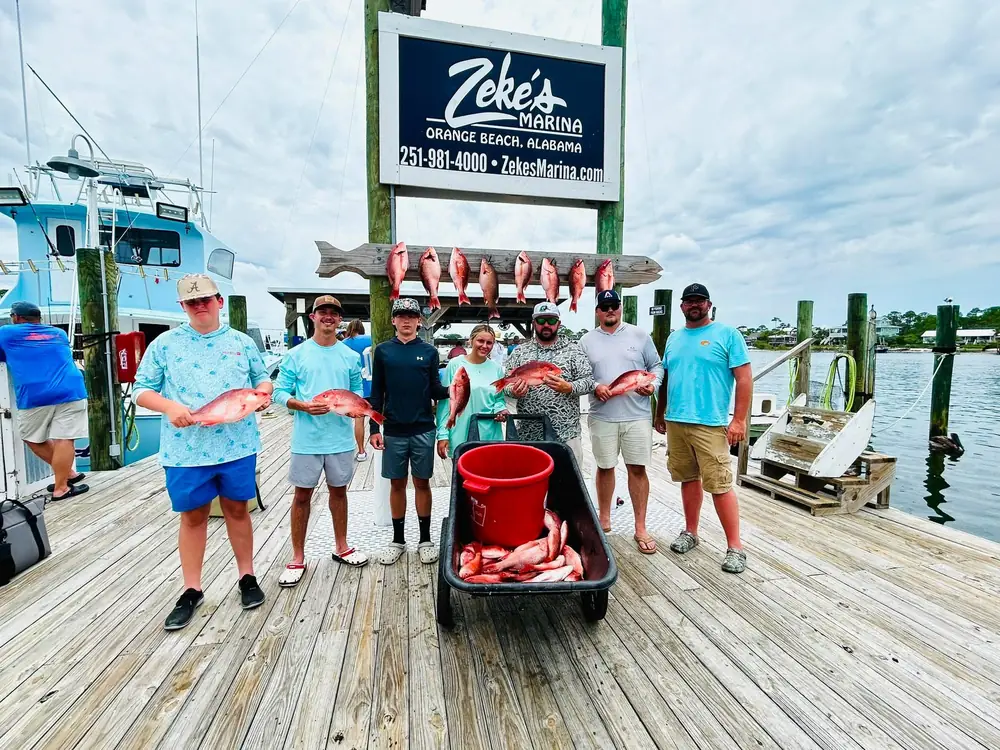 A charter group with snapper under the Zeke's Marina sign