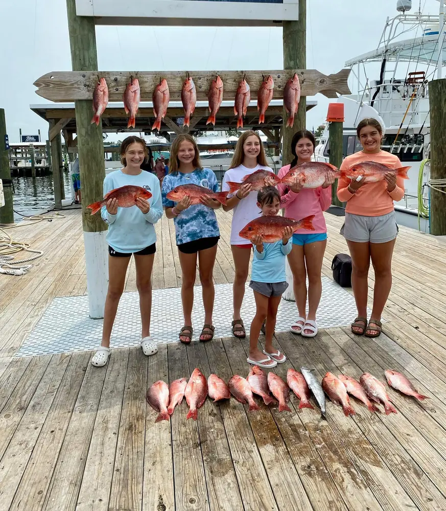 Young anglers with their red snapper laid out on the dock