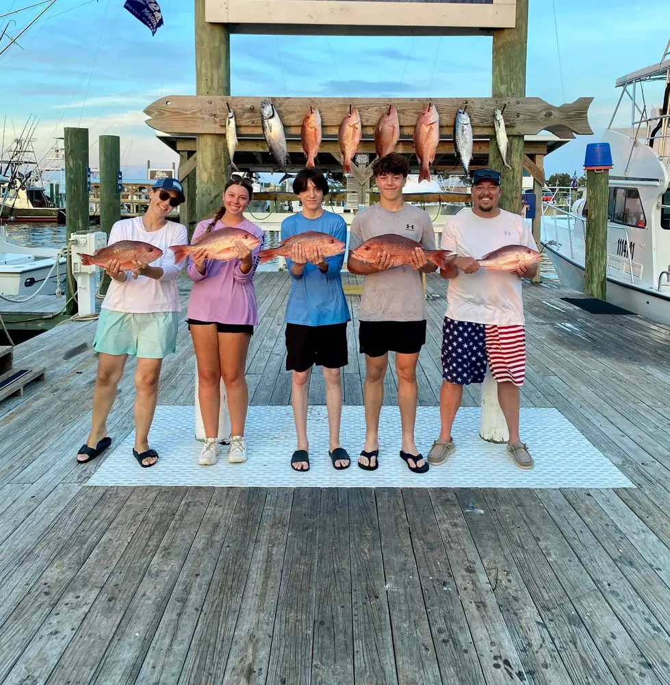 A group of teens with their red snapper at the marina