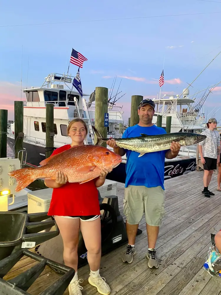 Anglers with a red snapper and a king mackerel at the dock