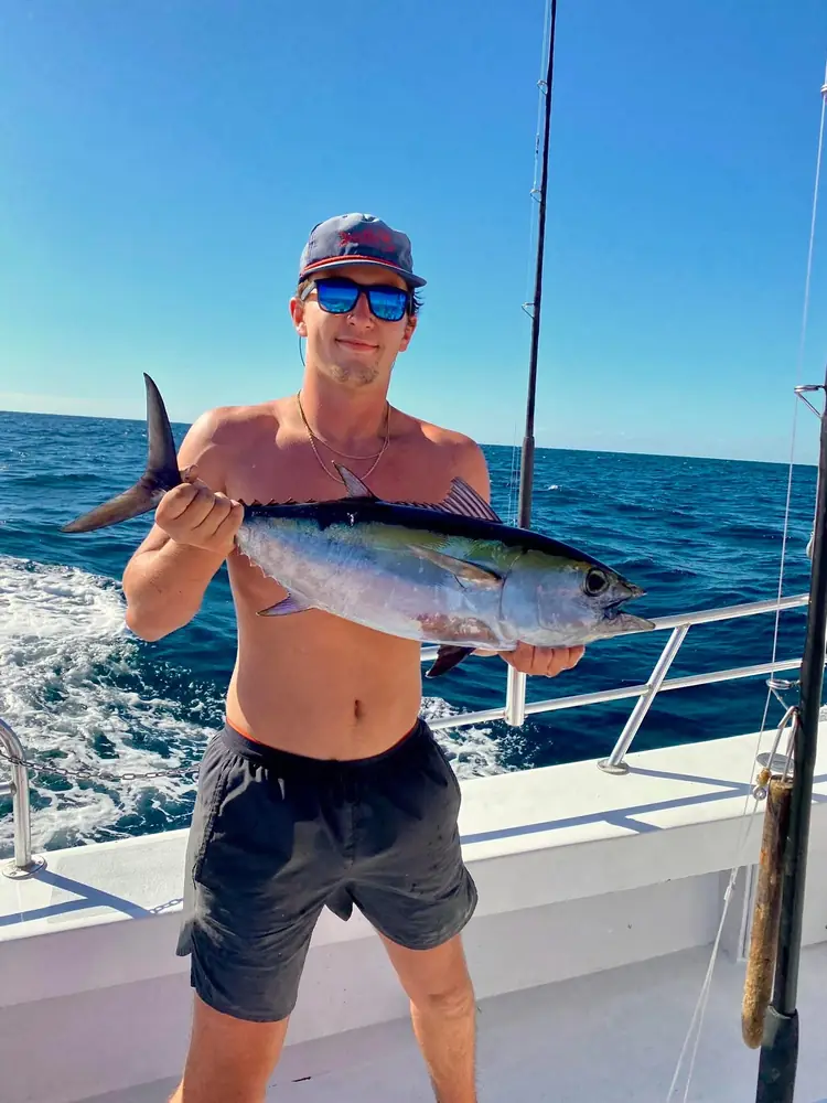 An angler with a blackfin tuna on the back deck
