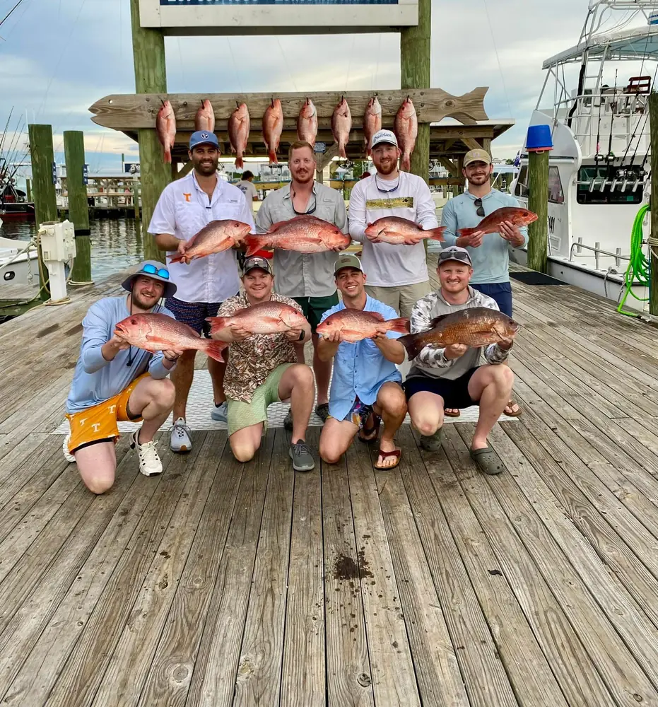 A charter group with red snapper under the fish rack