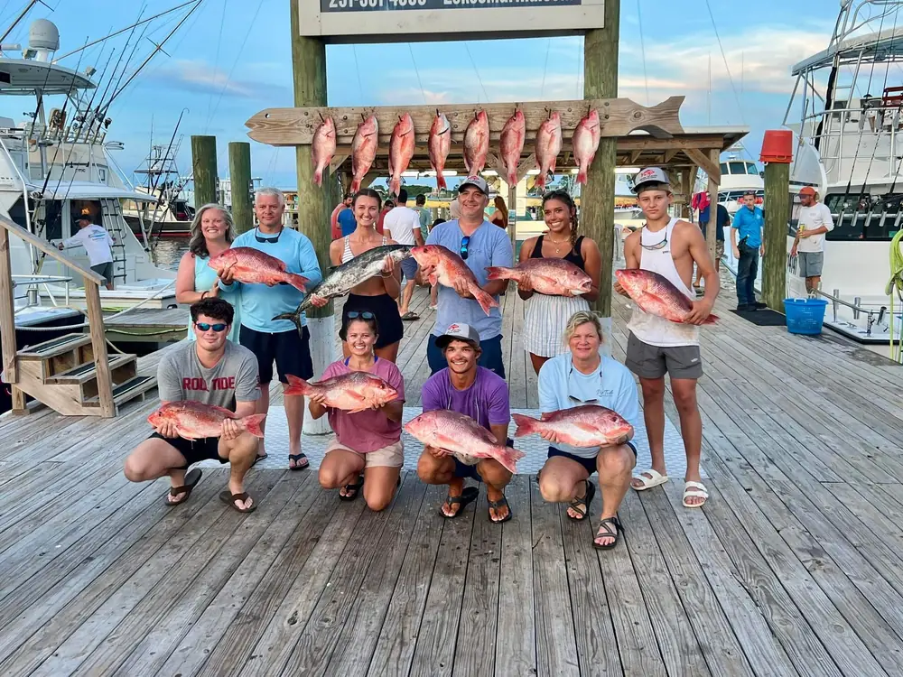 A group charter with snapper hanging behind them