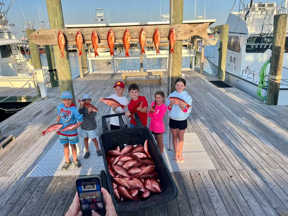 Young anglers with a cart of red snapper at the marina