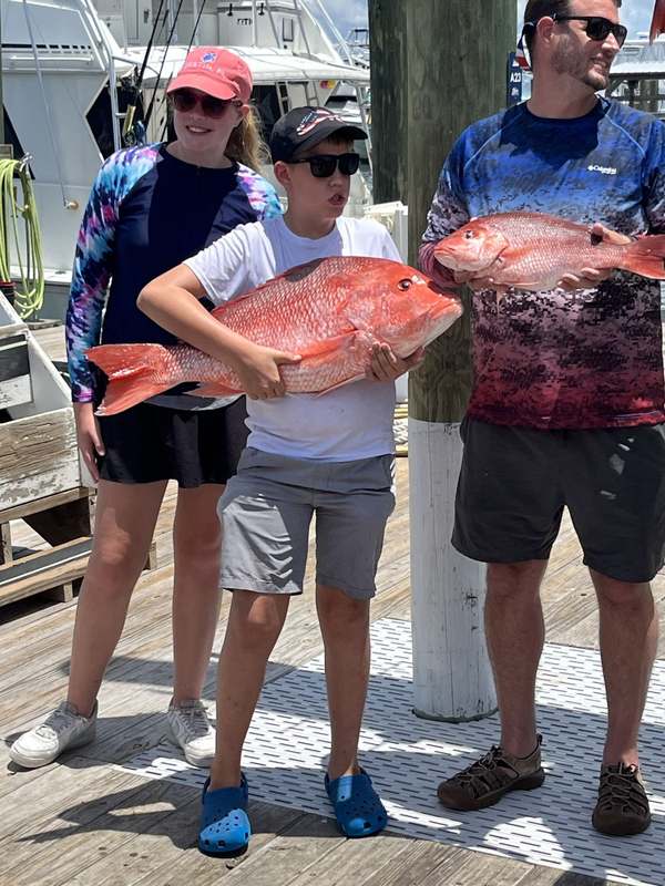 Two anglers on the dock with a pair of trophy red snapper