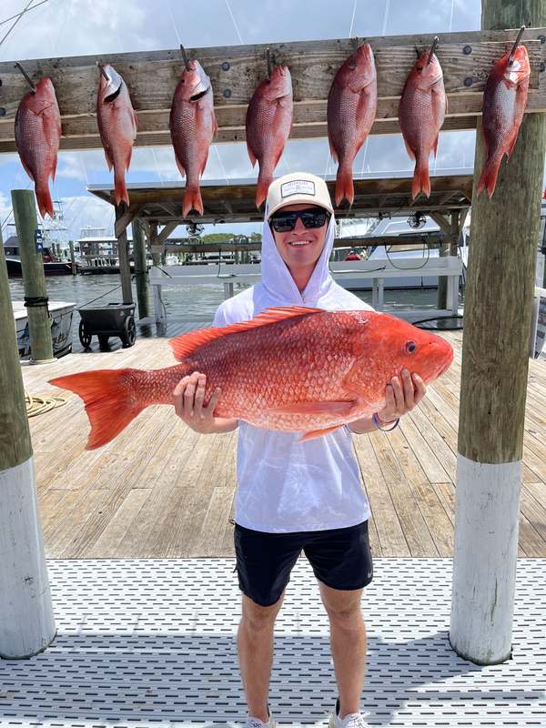 An angler cradling a wide-shouldered red snapper at Zeke's Landing