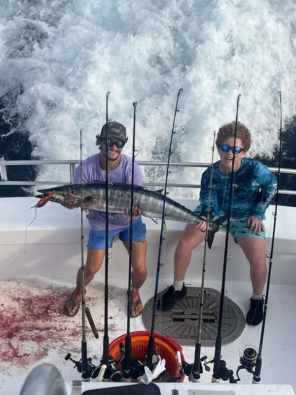 Anglers with a wahoo taken trolling offshore