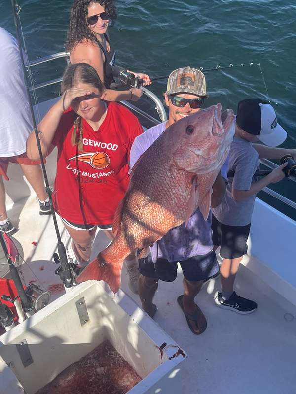 A young angler with a Gulf grouper caught bottom fishing