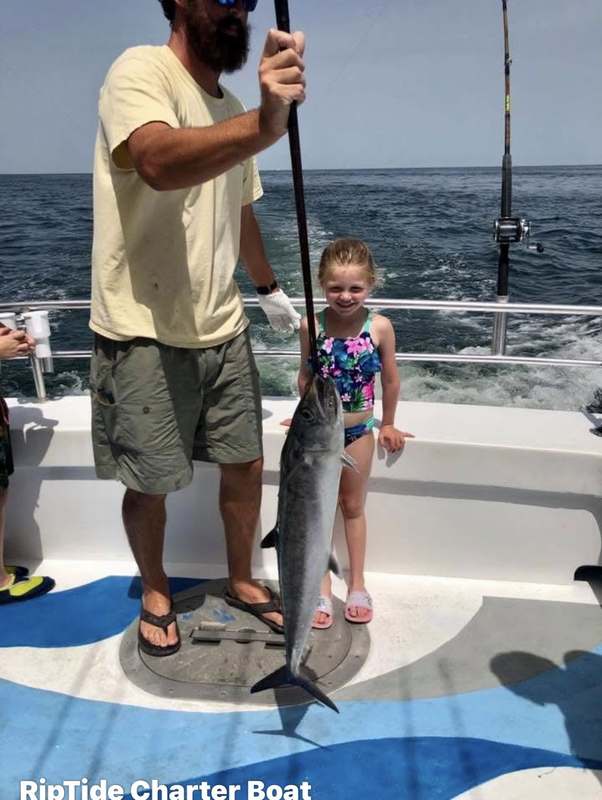 A young angler with her first billfish alongside the boat