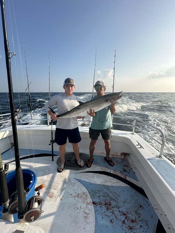 A guest holding a king mackerel taken on a trolling spread