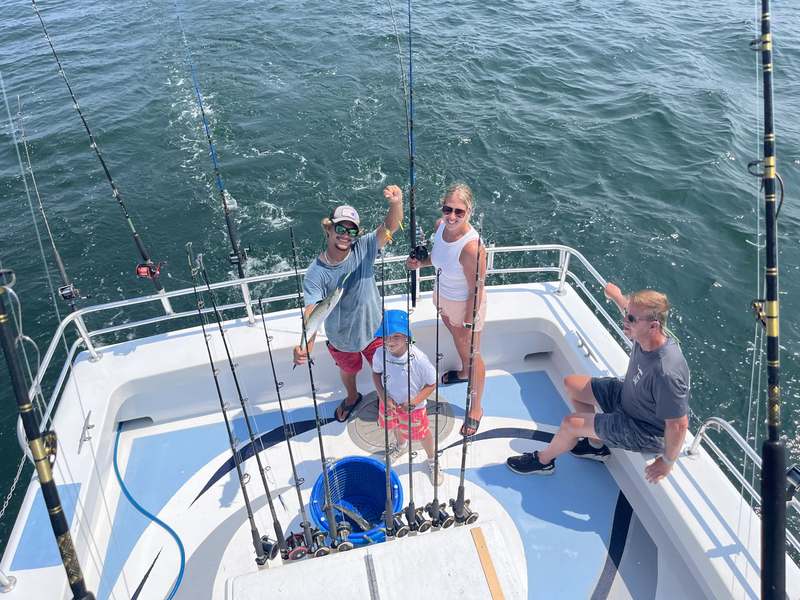 A family fishing together from the deck of the Rip Current