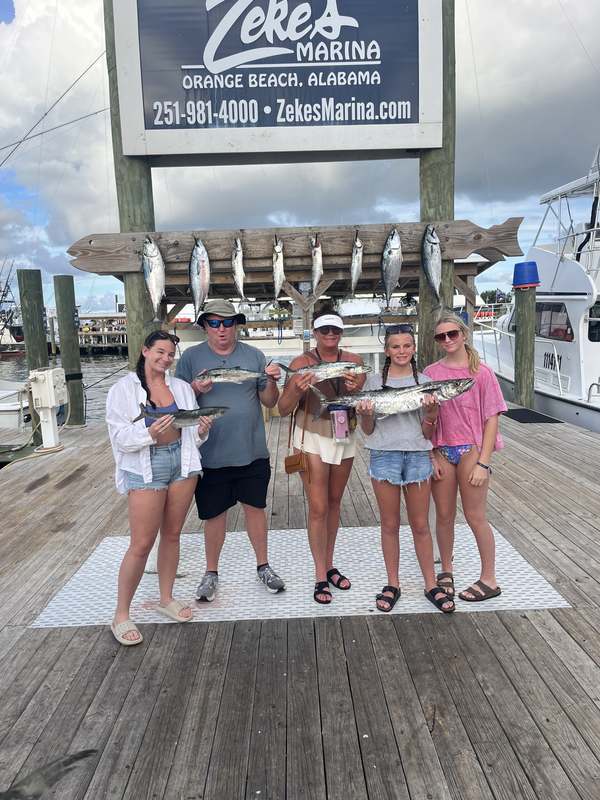 A family with their king mackerel at the Zeke's Landing fish rack