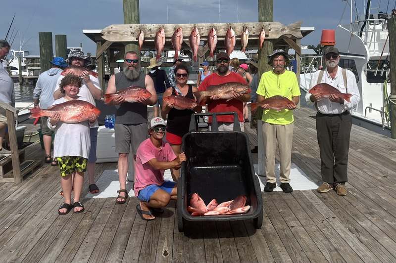 A group charter posing with the day's snapper haul