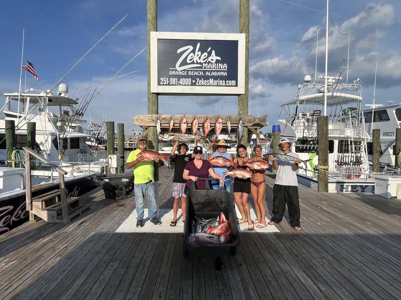 Guests of all ages with their catch at the marina