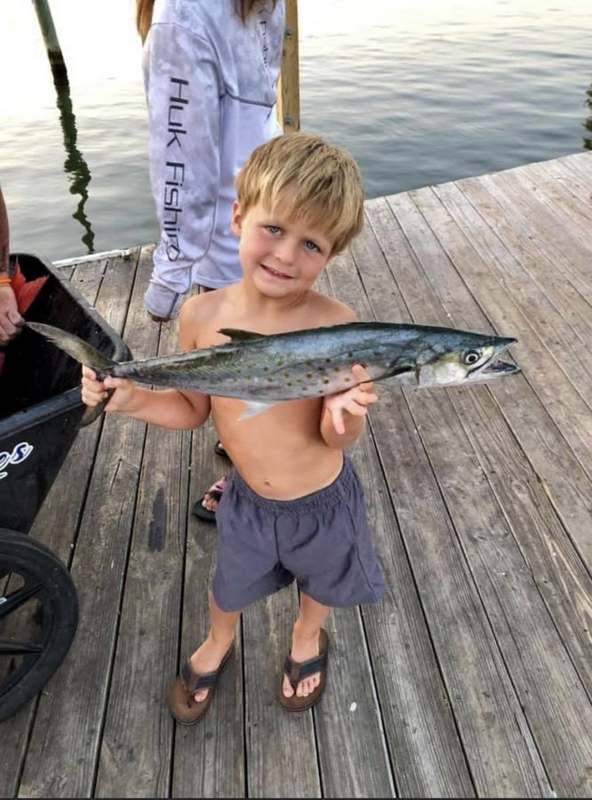 A young angler holding an amberjack at Zeke's Landing