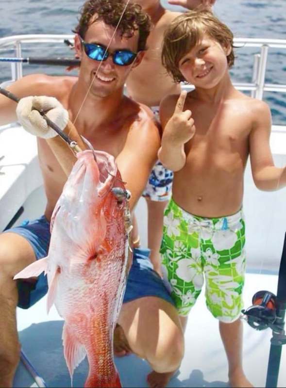 Two boys with a red snapper on the back deck