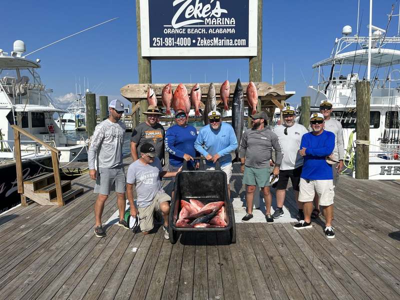 A group charter with their catch under the Zeke's Marina sign