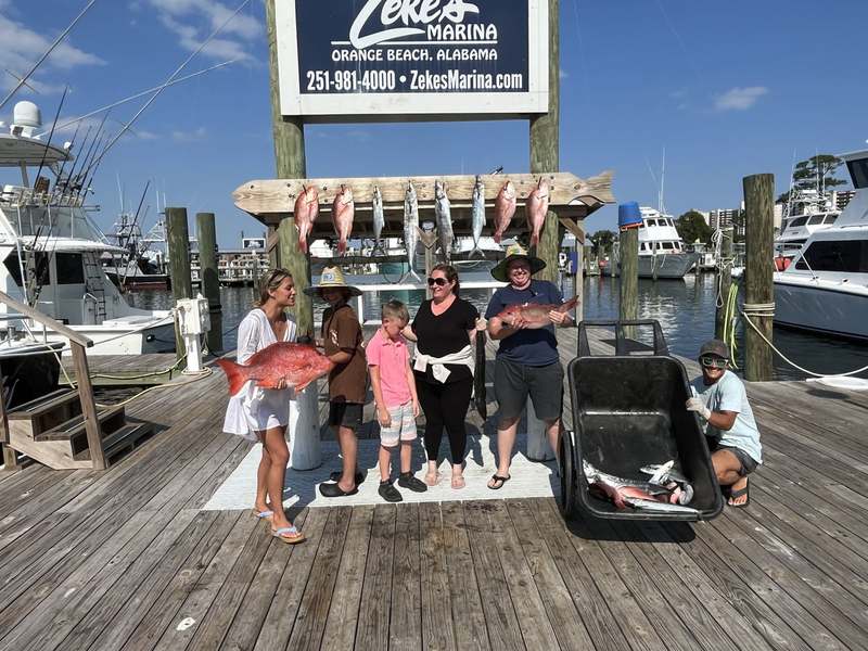 Guests posing with hanging snapper at Zeke's Landing