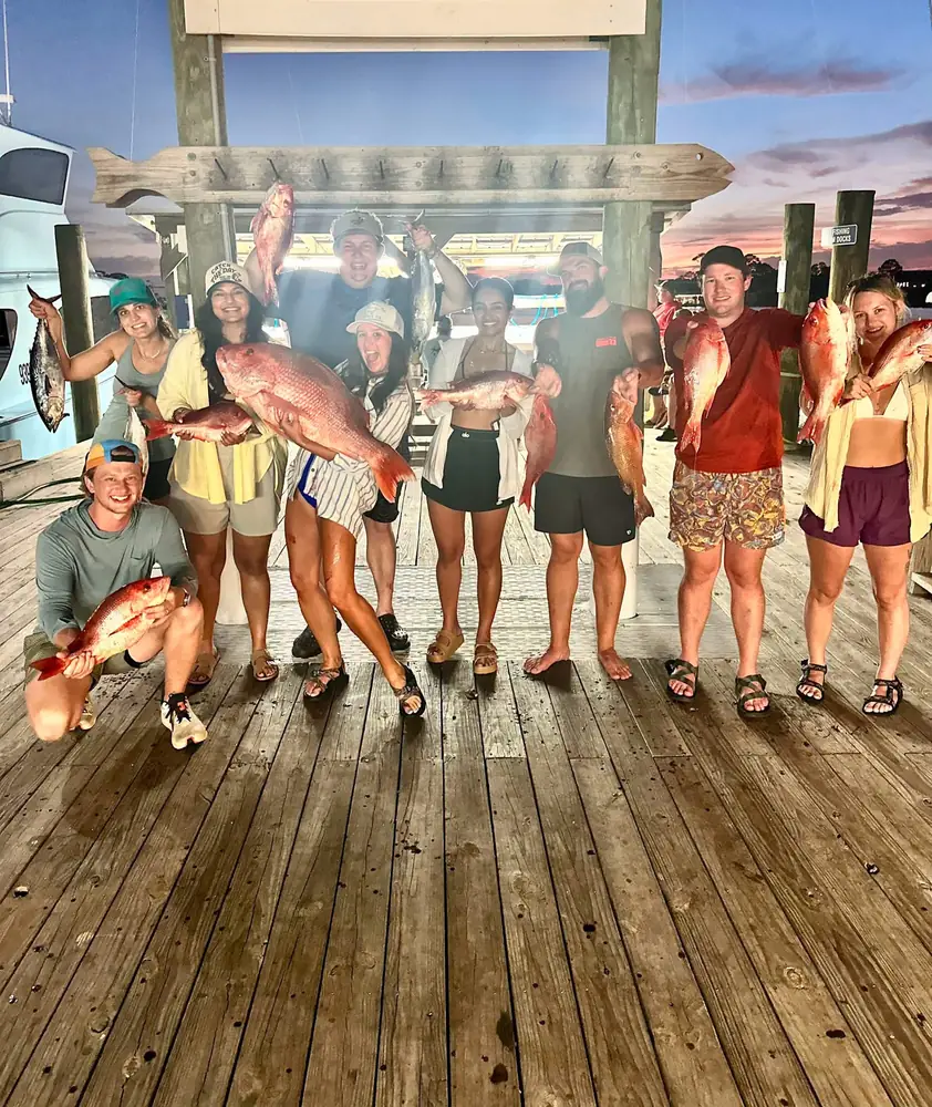 A group of guests with their snapper catch on the Orange Beach dock