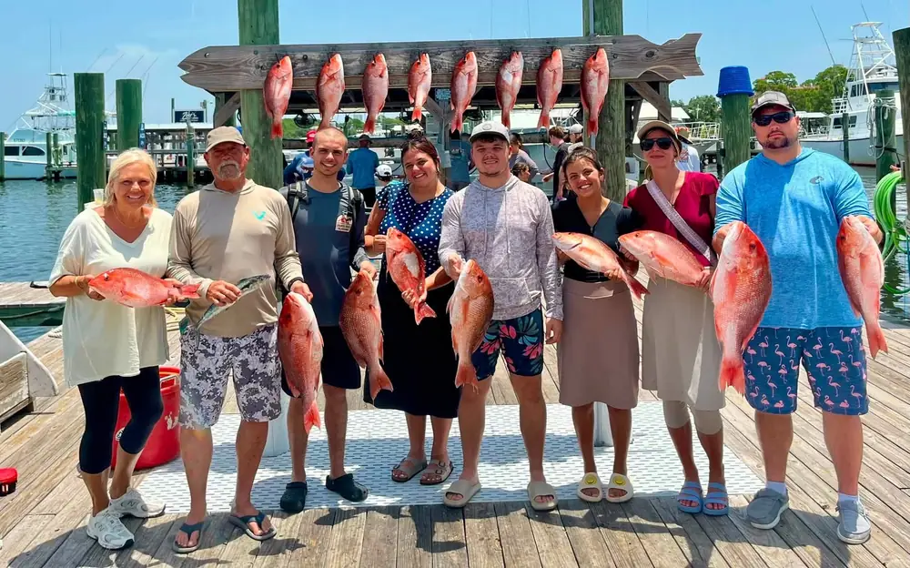 A group of guests with their red snapper at the marina