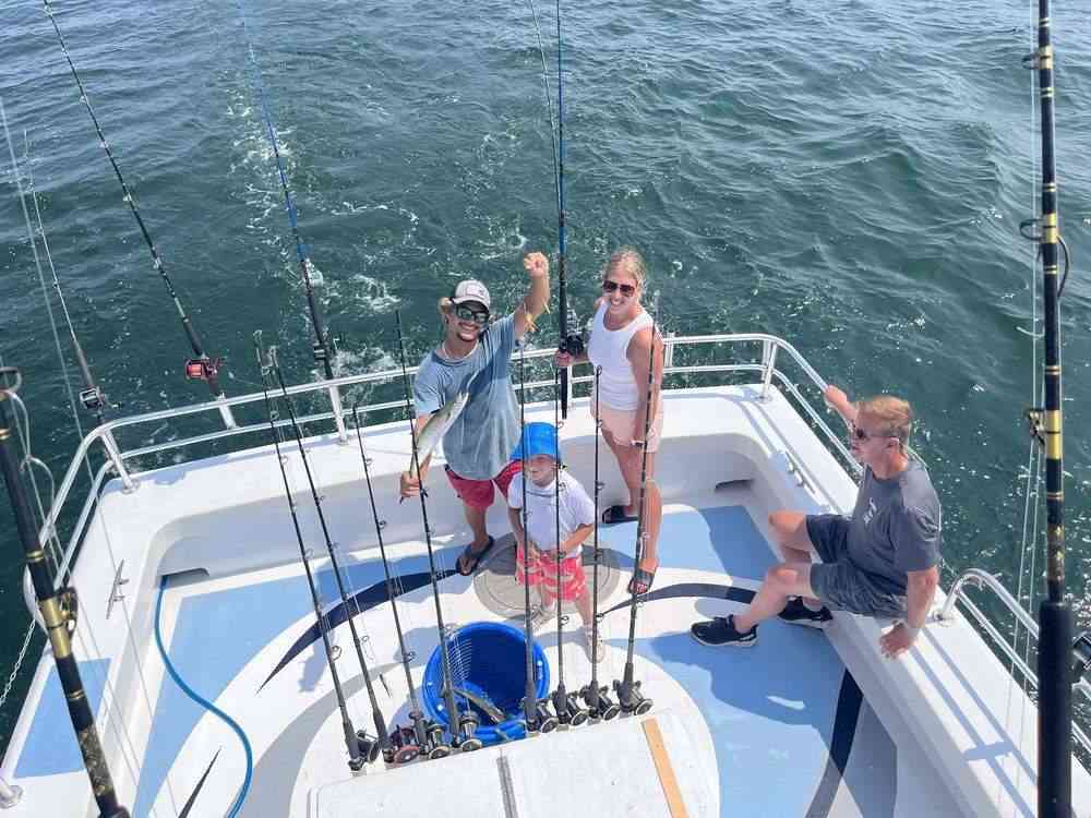 A family fishing together from the walk-around deck of the Rip Current