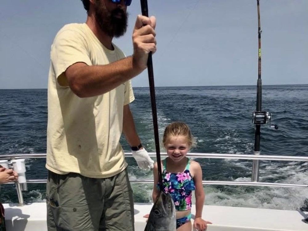 A young angler with her catch alongside the boat
